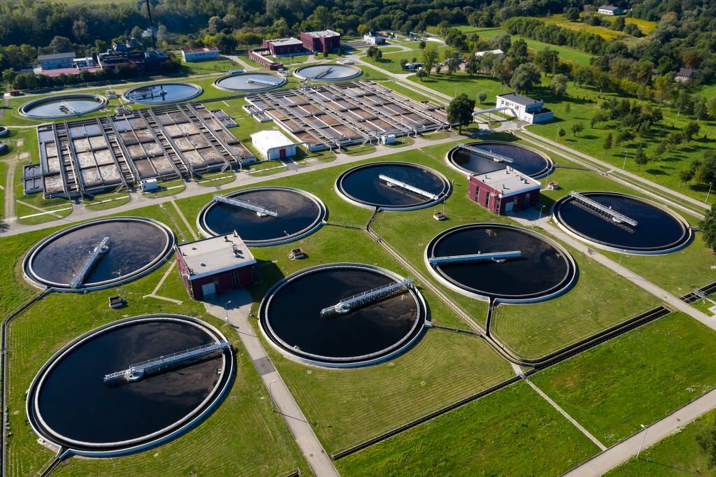 Aerial view of a sewage treatment plant with circular clarifiers and aeration basins